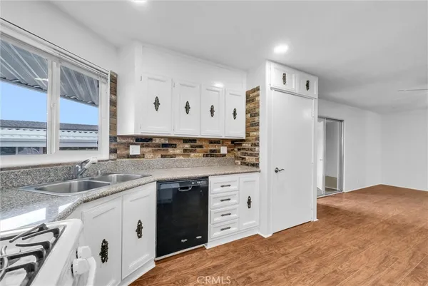 a kitchen with granite countertop a sink stove and refrigerator
