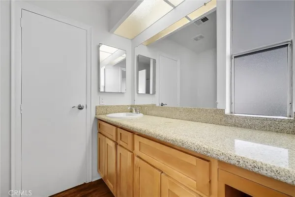 a bathroom with a granite countertop sink and a mirror