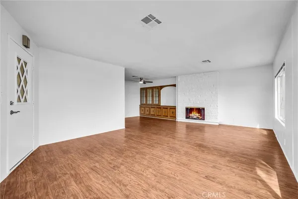 a view of empty room with wooden floor and window