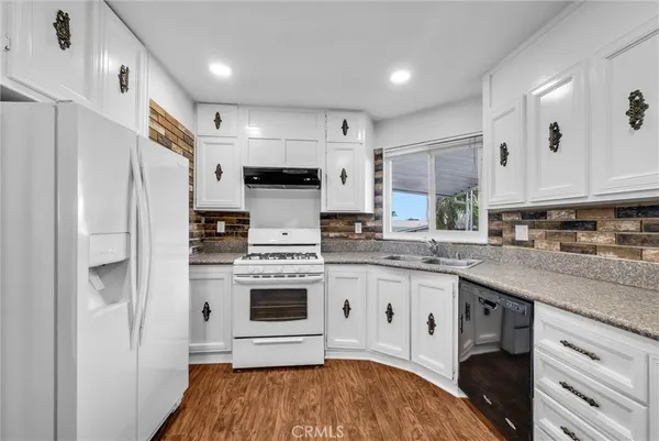 a kitchen with stainless steel appliances granite countertop a stove a refrigerator and a stove