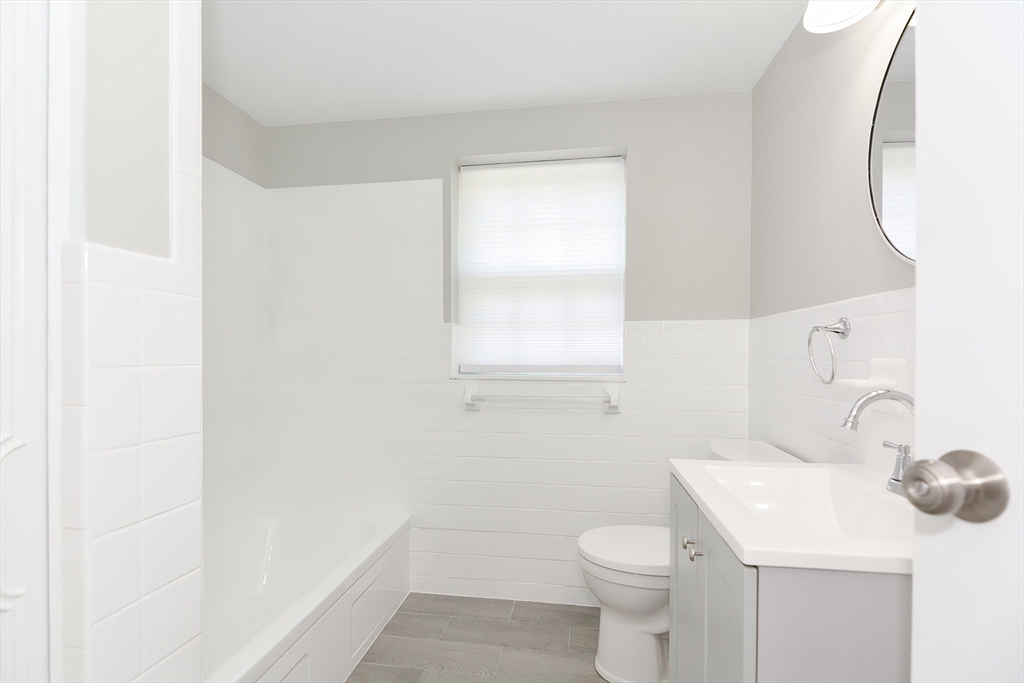 149 Lake Shore Road, Unit 2 Boston, MA 02135 - Photo 23 of 38 a bathroom with a sink a toilet and a mirror