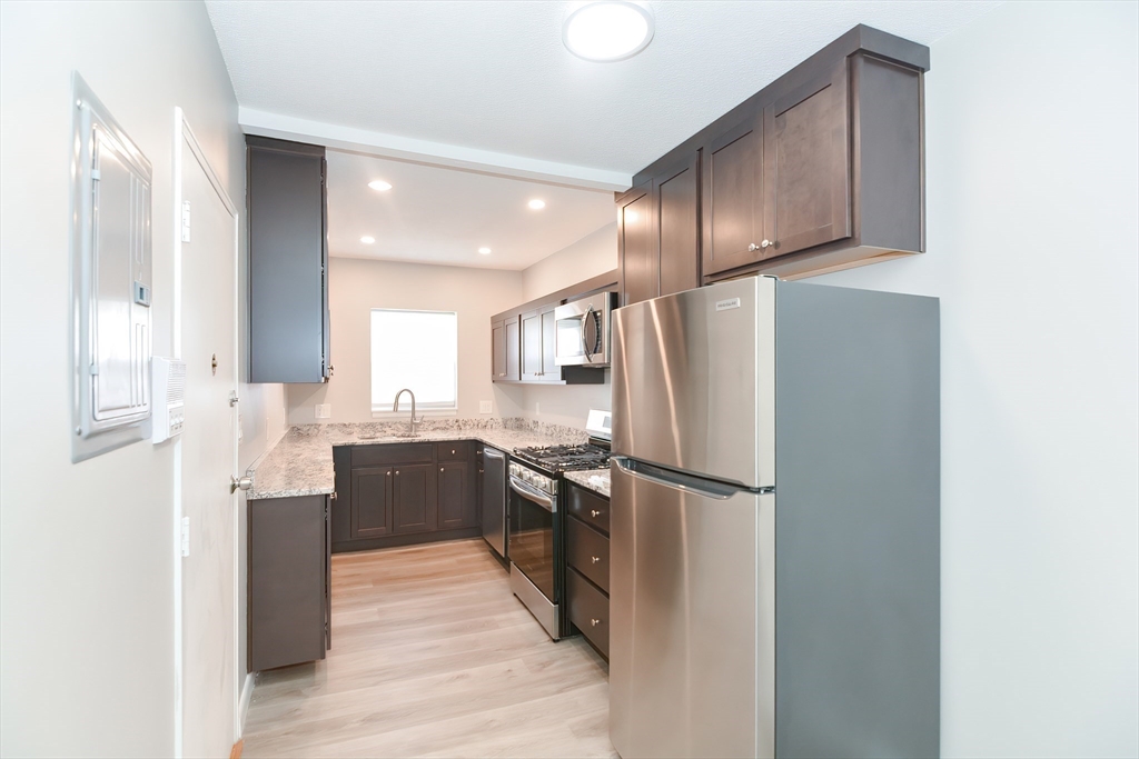 149 Lake Shore Road, Unit 2 Boston, MA 02135 - Photo 3 of 38 a kitchen with stainless steel appliances granite countertop a refrigerator and a sink