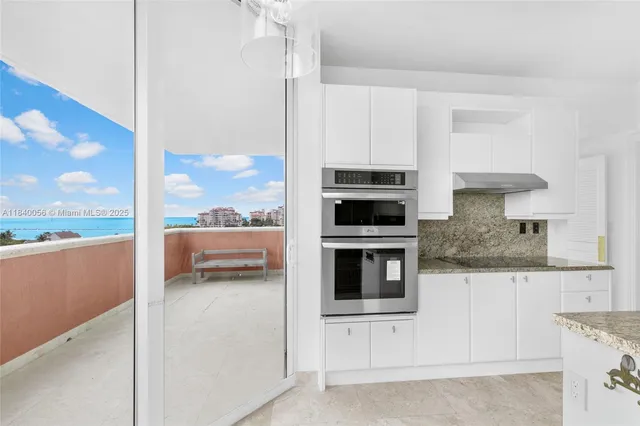 a kitchen with granite countertop white cabinets and a sink