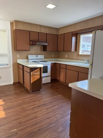 a kitchen with stainless steel appliances kitchen island granite countertop a stove a sink and a refrigerator