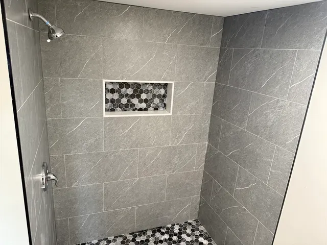 a view of an empty room with wooden floor and windows