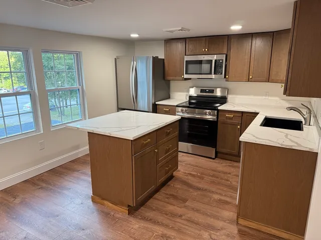 a kitchen with stainless steel appliances a refrigerator a stove a microwave and cabinets