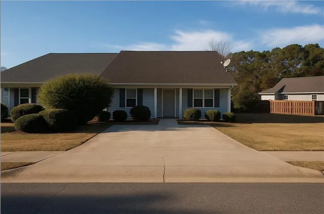 a front view of a house with a yard and potted plants
