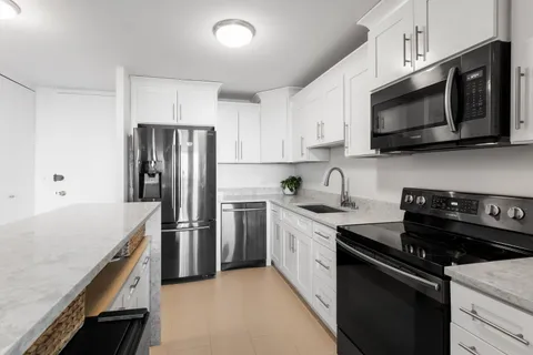 a kitchen with stainless steel appliances granite countertop a stove microwave sink and refrigerator
