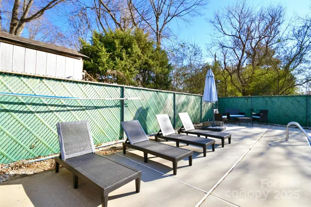 a roof deck with table and chairs and potted plants