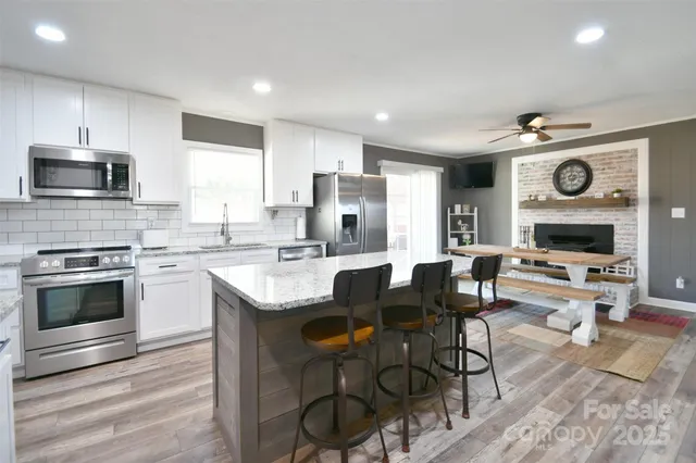 a kitchen with a table chairs microwave and cabinets