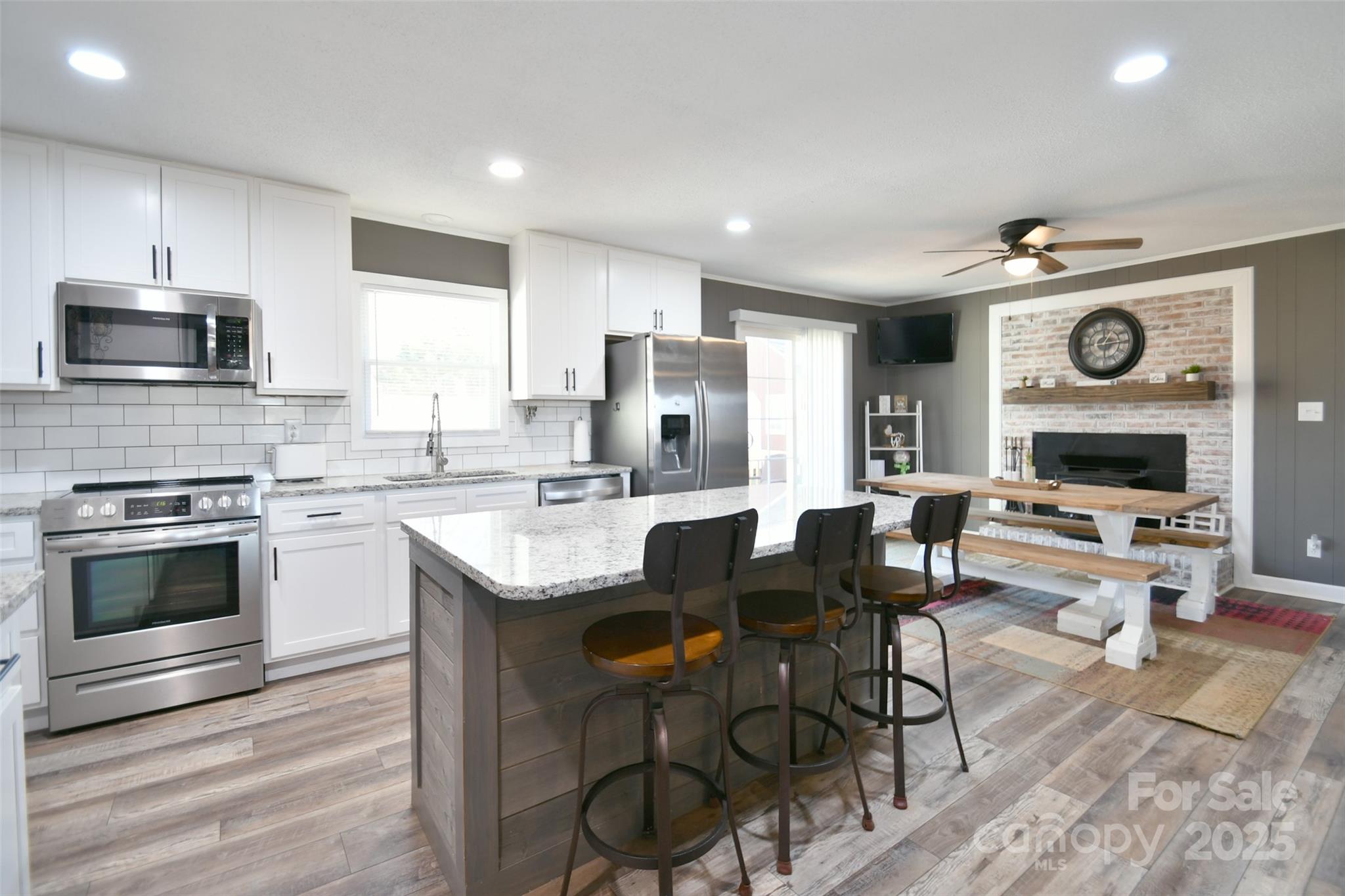 1820 Irish Potato Road Concord, NC 28025 - Photo 10 of 35 a kitchen with a table chairs microwave and cabinets