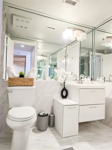 a bathroom with a sink mirror toilet and shower