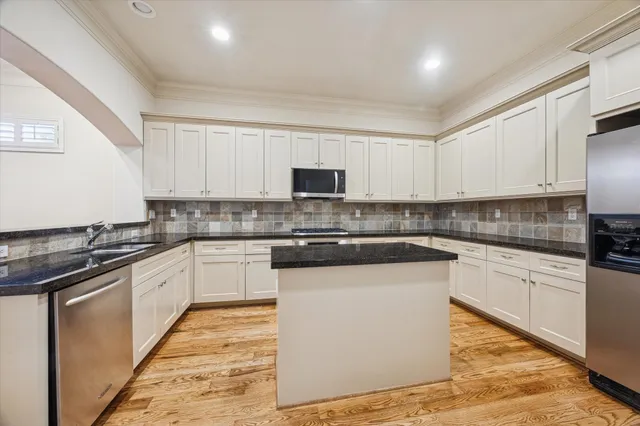 an empty room with wooden floor fireplace and windows
