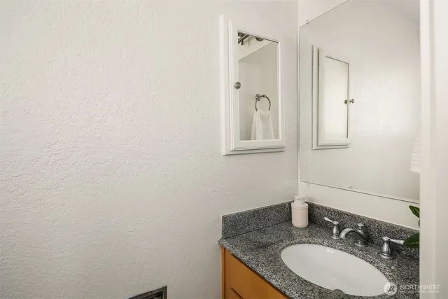 a bathroom with a granite countertop sink and a mirror