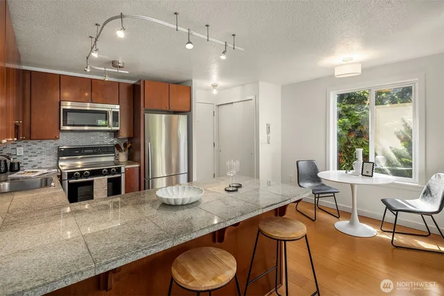 a large kitchen with kitchen island a large counter space appliances and a dining table