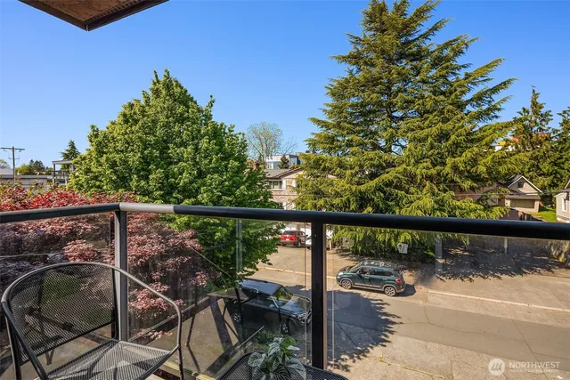 a view of a balcony with chairs and wooden fence