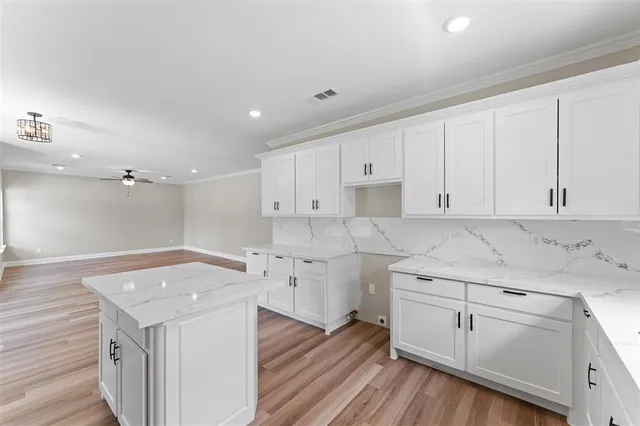 a kitchen with a sink cabinets and wooden floor