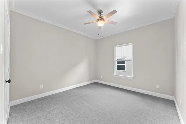 an empty room with closet and a chandelier fan
