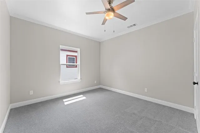 an empty room with a ceiling fan and a window