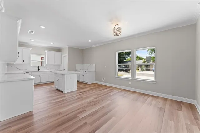 a living room with wooden floors and kitchen view
