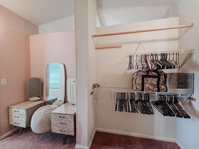 a view of walk in closet with clothes and shoes