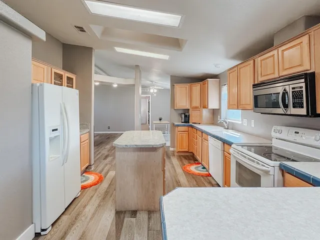 a kitchen with stainless steel appliances a stove a sink a microwave and cabinets