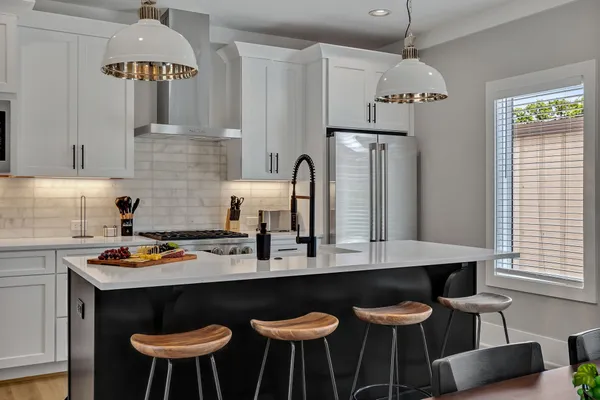 a kitchen with stainless steel appliances a table chairs and a refrigerator