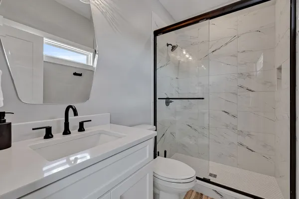 a bathroom with a sink a toilet and shower