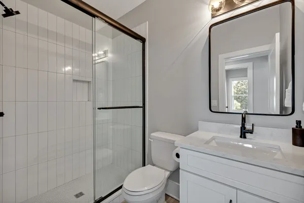 a bathroom with a sink a toilet and shower
