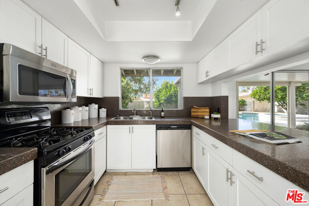 68305 Encinitas Road Cathedral City, CA 92234 - Photo 22 of 33 a kitchen with stainless steel appliances a stove sink microwave and cabinets