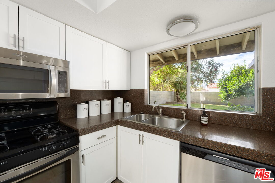68305 Encinitas Road Cathedral City, CA 92234 - Photo 23 of 33 a kitchen with a sink appliances and cabinets