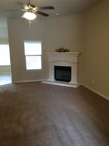 an empty room with a fireplace and chandelier