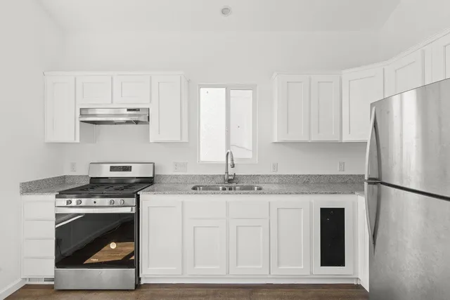 a kitchen with cabinets appliances and a counter space