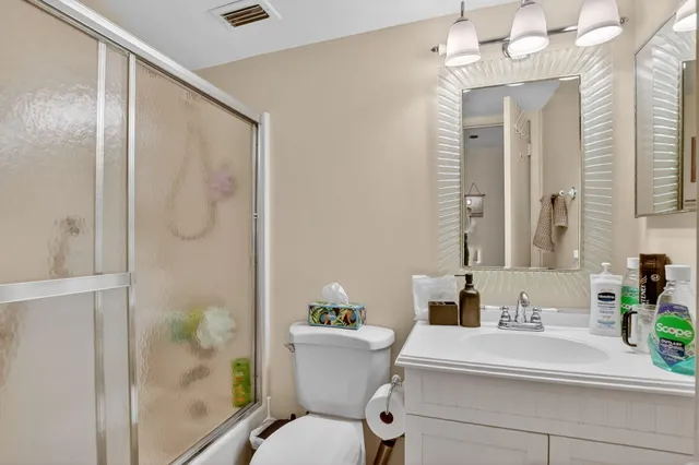 a bathroom with a sink mirror vanity and toilet