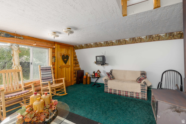 23 Scare Canyon, Unit 23 Logan, UT 84321 - Photo 12 of 33 Living space featuring a large window, wood-finish door, and wood-finish ceiling beams