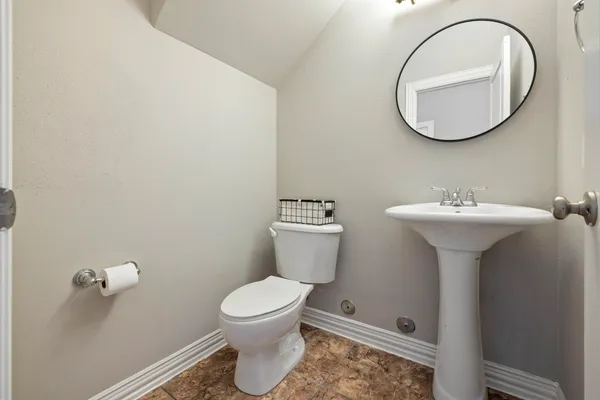a bathroom with a sink toilet and a mirror