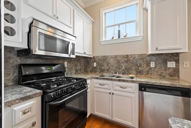 a kitchen with granite countertop white cabinets and appliances