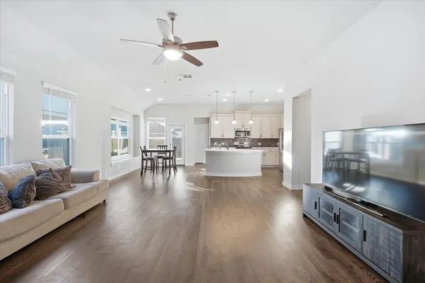 a living room with furniture and kitchen view
