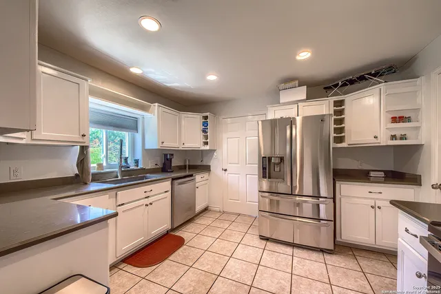 a kitchen with granite countertop a refrigerator and a sink