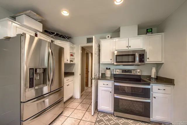 a kitchen with stainless steel appliances a refrigerator sink and microwave