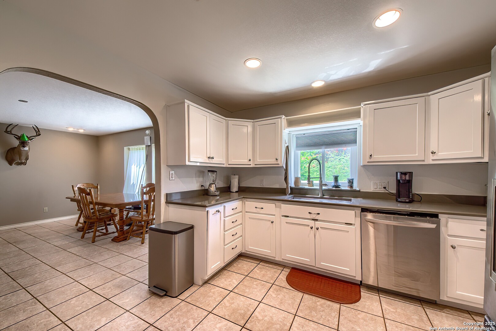 5464 Coughran Road Pleasanton, TX 78064 - Photo 27 of 55 a kitchen with a sink white cabinets and appliances
