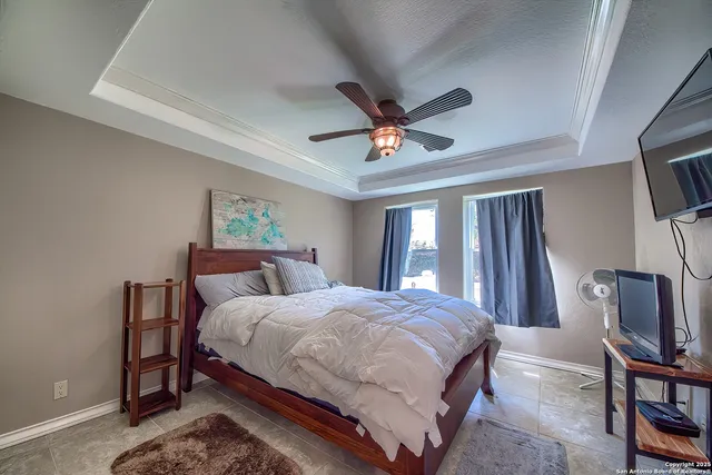 a bedroom with a bed a window and television