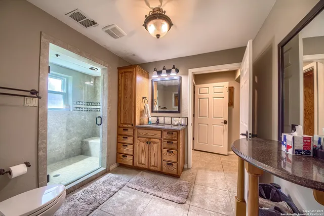a spacious bathroom with a double vanity sink a mirror and a shower
