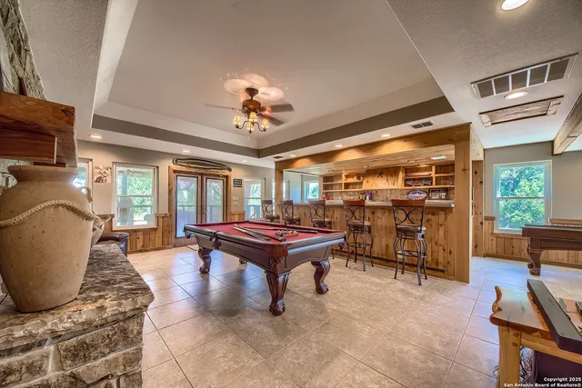 a living room with furniture a flat screen tv and floor to ceiling window