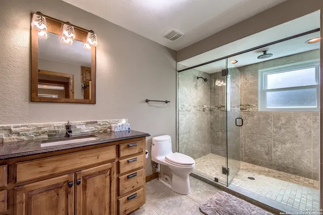 a bathroom with a sink a toilet and shower