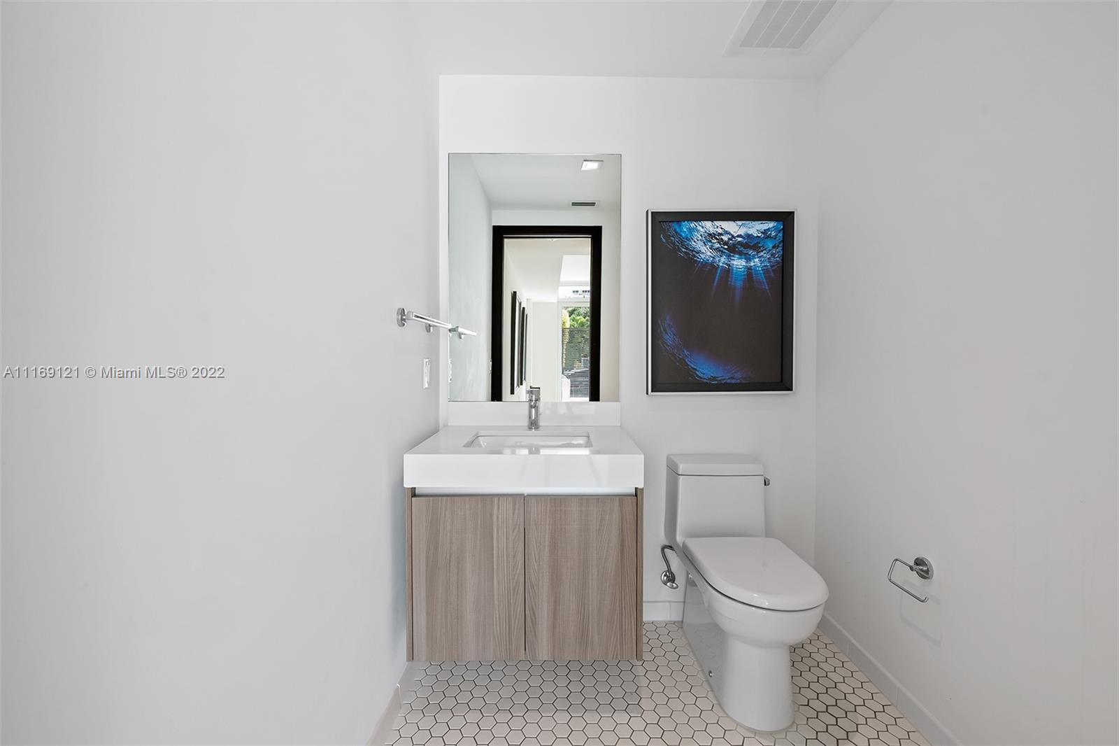 401 North Birch Road, Unit TH7 Fort Lauderdale, FL 33304 - Photo 11 of 29 a bathroom with a toilet a sink and mirror