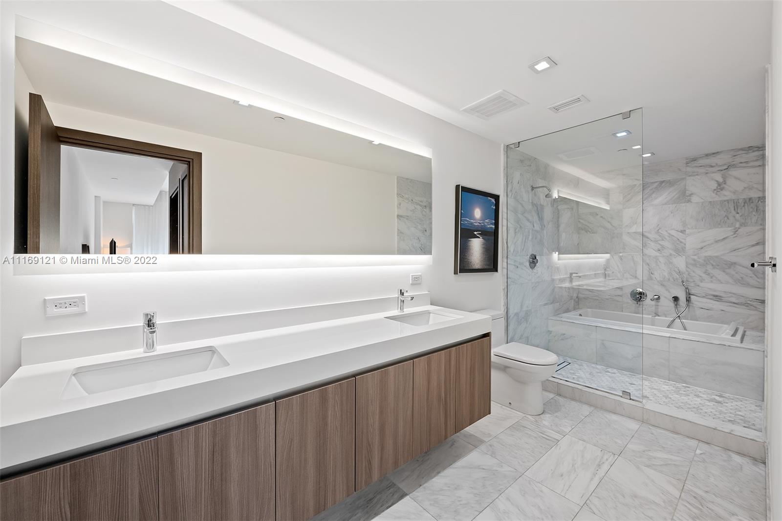 401 North Birch Road, Unit TH7 Fort Lauderdale, FL 33304 - Photo 13 of 29 a bathroom with a double vanity sink toilet mirror and bathtub