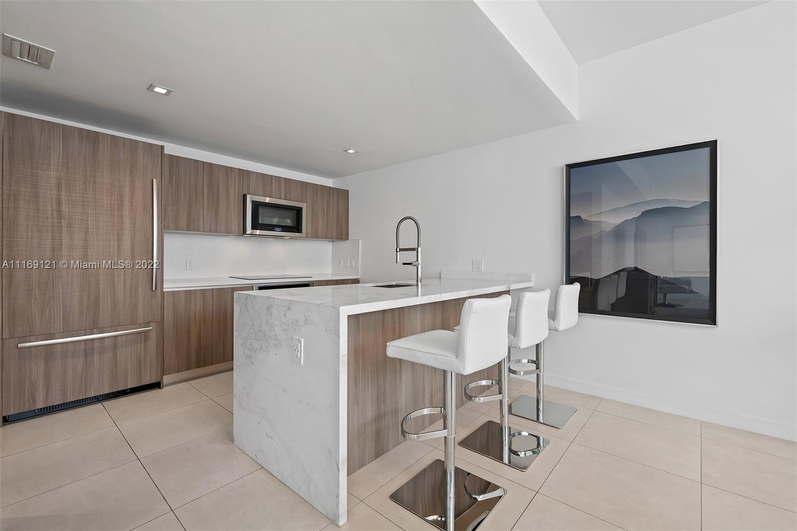 401 North Birch Road, Unit TH7 Fort Lauderdale, FL 33304 - Photo 9 of 29 a kitchen with stainless steel appliances a refrigerator and microwave