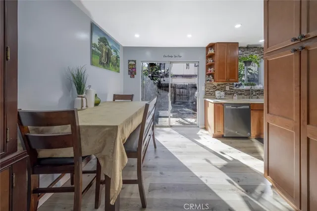 a kitchen with stainless steel appliances kitchen island granite countertop a table chairs and a refrigerator