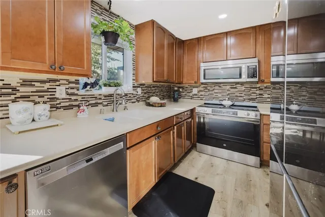 a kitchen with stainless steel appliances granite countertop a sink stove and refrigerator